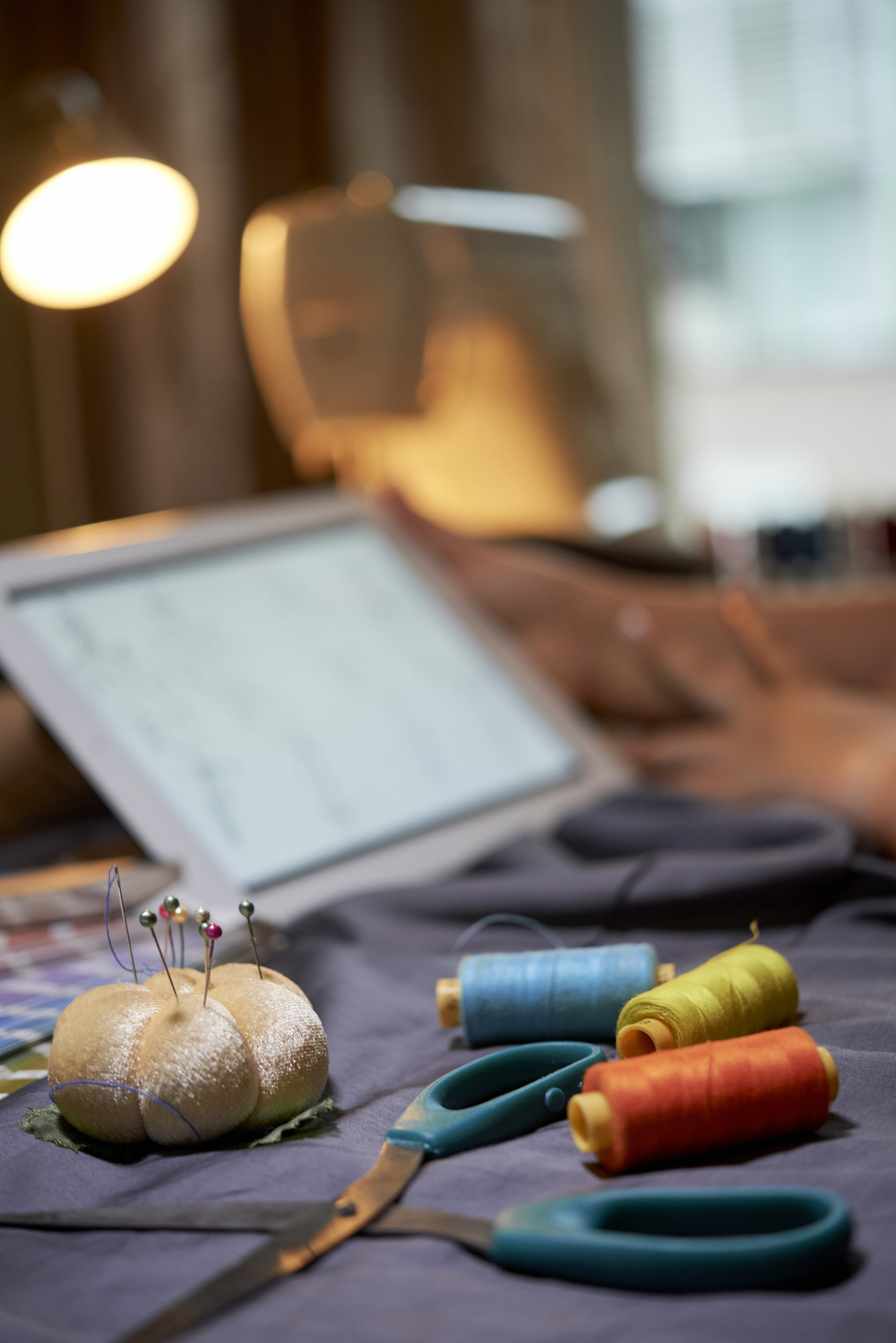 Tavolo da lavoro con filati e telai ordinati in un atelier